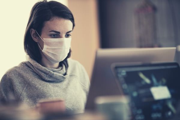 ask for pay raise pandemic woman in gray hoodie wearing white mask looking at the monitor
