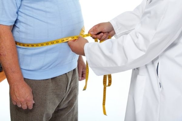 doctor measuring obese man waist body congrats on weight loss