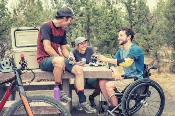group-of-men-chilling-drinking-beverage-in-can-one-sitting-on-wheelchair