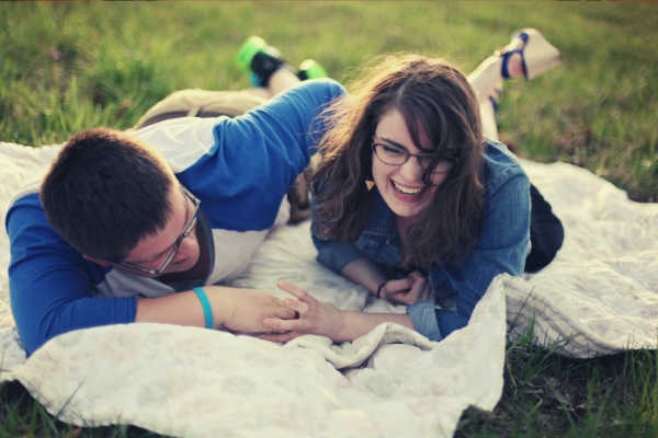 feature-happy-couple-with-eyeglasses-lying-on-green-grass