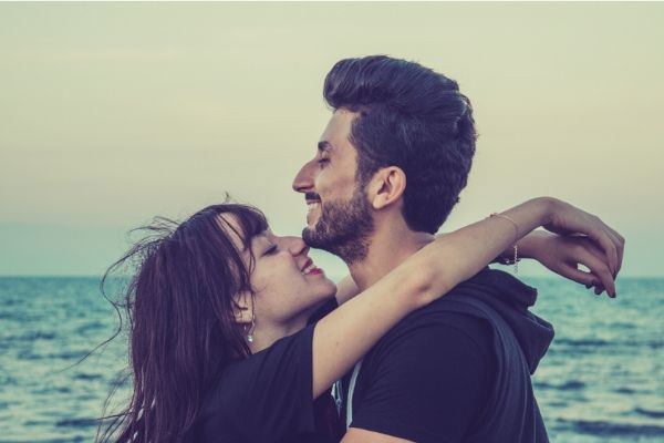 man-and-woman-happy-in-black-facing-each-other-on-the-beach