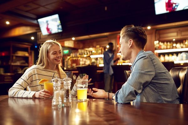 Man woman drinking talking in bar asks if you are single