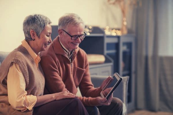 old-couple-smiling-while-looking-at-a-tablet-words-to-describe-elderly