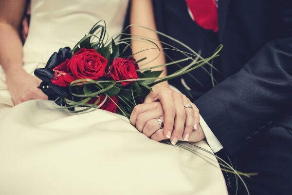 wedding-couple-holding-hands-bouquet-roses