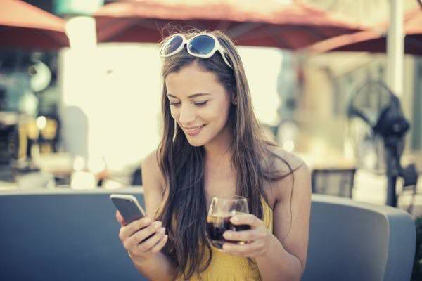 woman-holding-smartphone-and-glass