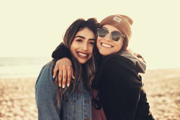 woman-hugging-another-woman-while-smiling