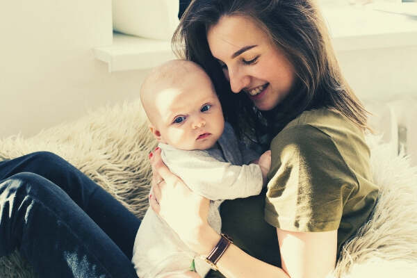 feature-woman-in-green-shirt-holding-baby-while-sitting