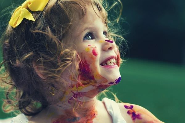 feature-words-to-describe-child-cute-girl-in-tank-top-paint-all-over-her-face-and-body